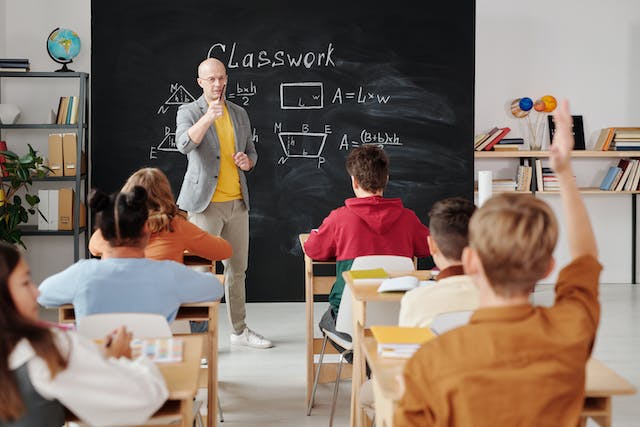 math teacher standing in front of a class lecturing